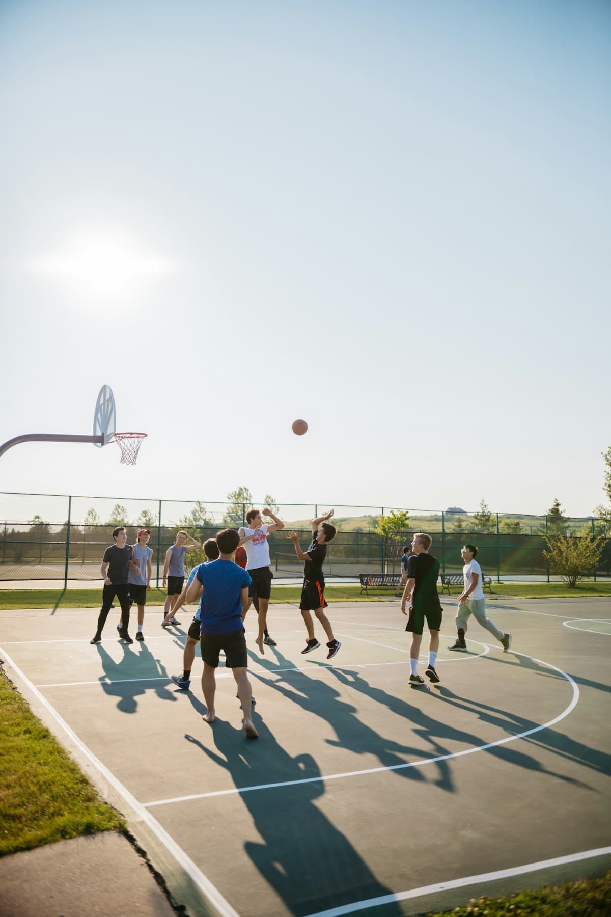 A group playing basketball on an outdoor court
