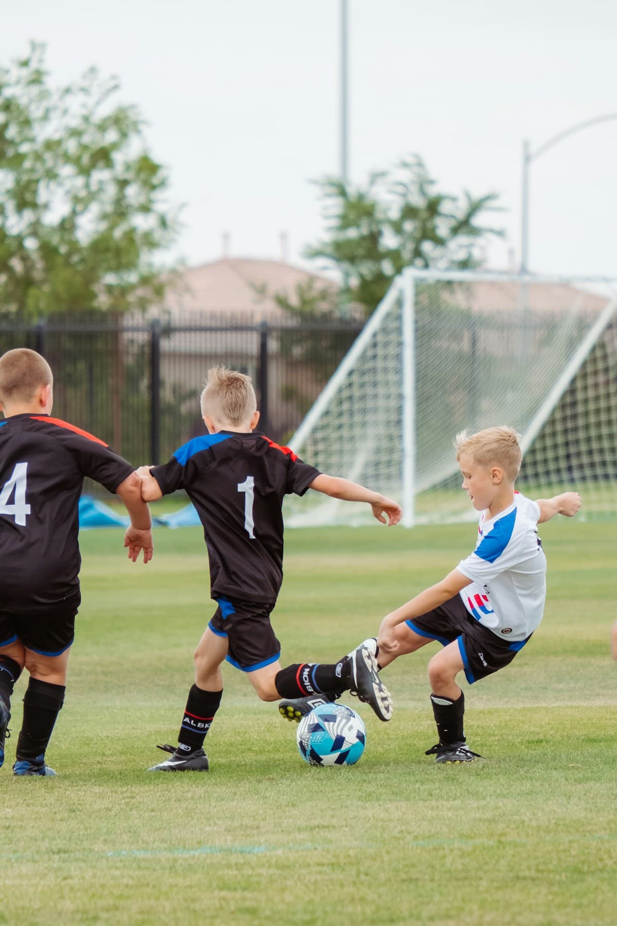 Children playing football on a grass field