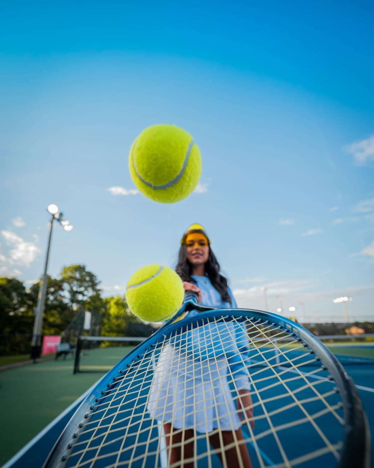 Tennis player practicing with a racket and tennis balls